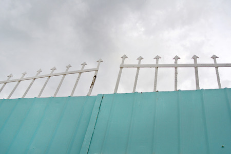 blue and white metallic gate on background sky