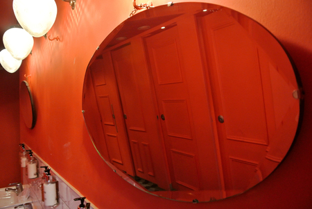 oval mirror on red wallの写真素材