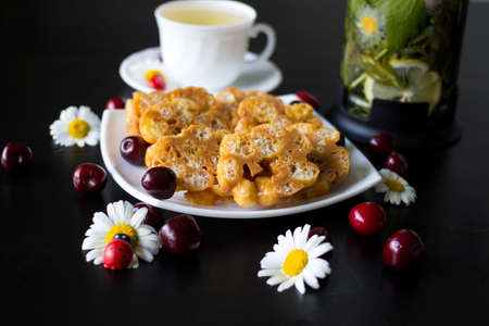 On a white plate is a dessert of toffee and corn sticks, decorated with daisies with ladybirds and...
