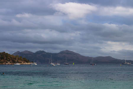 View from Formentor beach on the sea, yachts, mountains and the sky in clouds. Majorca. Spain.の写真素材