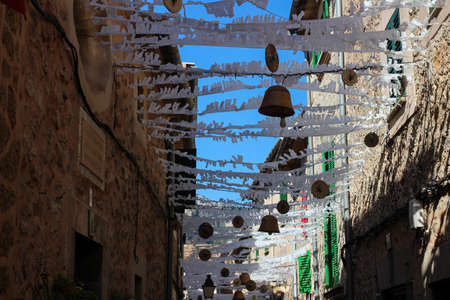sun protection and wicker products suspended between houses on a narrow street in the city of Valdemossa. Majorca. Spain.のeditorial素材