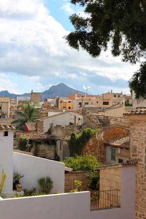 View of the roofs of houses in Alcudia against a cloudy sky. Alcudia. Majorca. Spain.の写真素材