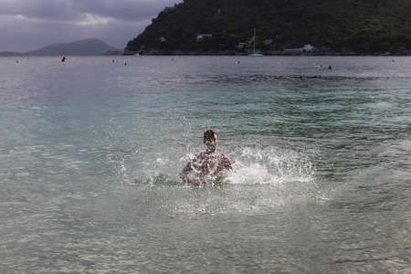 A young man is splashing in the sea on Formentor beach. Majorca. Spain.の写真素材
