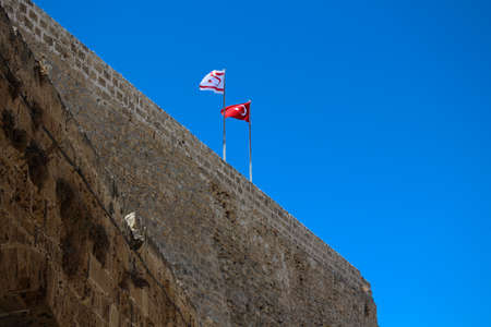 Two flags on the stone wall of the fortress of Kyrenia. Kyrenia. Cyprus.の写真素材