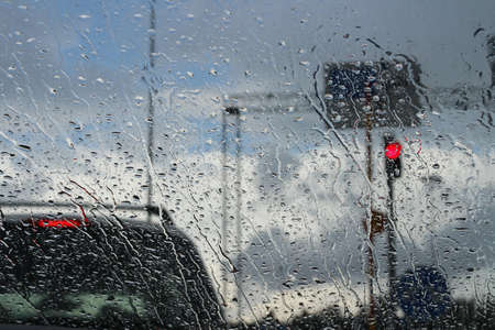 The windshield of a car standing at a traffic light in the rain.の写真素材