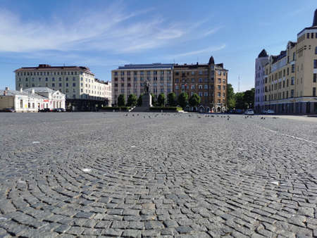 Red Square in the city of Vyborg, laid with paving stones, with a monument, surrounded by old...
