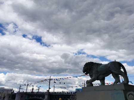 Lion sculpture on the background of the Palace Bridge, decorated with flags for the Navy Day.の写真素材