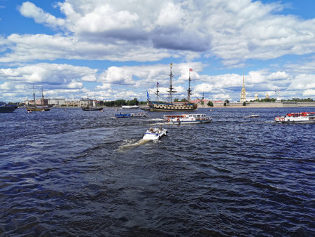 Boats and yachts with tourists sail to the Neva to see warships and sailboats for the Day of the...