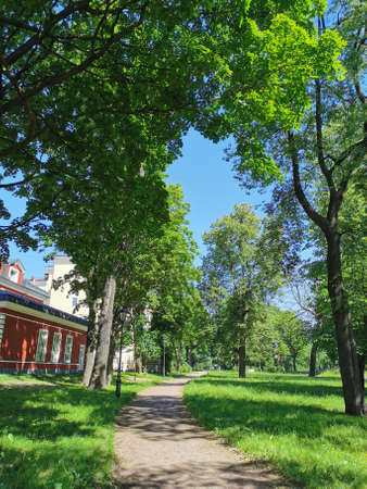 A path next to a beautiful old building in the Summer Garden of Kronstadt against the background of a blue cloudless skyの写真素材