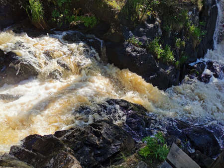 View of the Akhvenkoski waterfall on the Tokhmayoki River in Karelia from the pedestrian bridge...