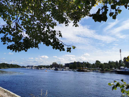 View of the yachts standing off the coast of Krestovsky Island, past which a boat sails against the...