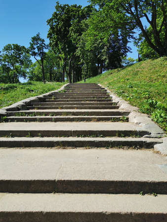 A view from below of a wide stone staircase in the Summer Garden of the city of Kronstadt against the background of a cloudless skyの写真素材