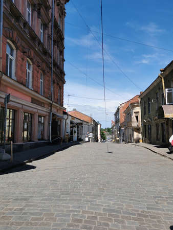 A cobbled, narrow, ancient street of the city of Vyborg on a sunny summer day.