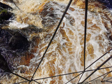 View of the Akhvenkoski waterfall on the Tokhmayoki River in Karelia from the pedestrian bridge passing over it.の写真素材