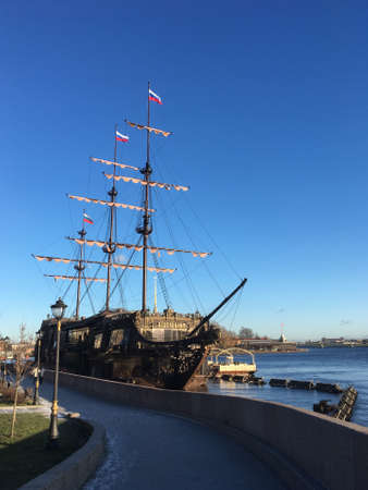 A beautiful carved restaurant ship moored in the Neva river on the Mytninskaya embankment of Saint Petersburg. Against a blue cloudless sky.の写真素材