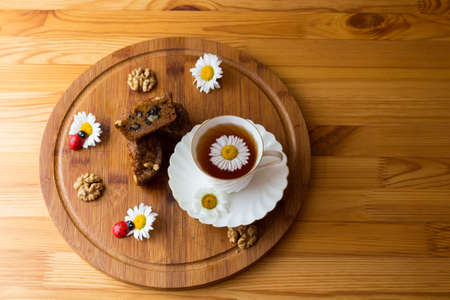 Top view of carrot cakes in a section with walnuts and spices, a white porcelain Cup with a saucer...