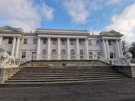 The entrance to the Elaginoostrovsky Palace with a staircase and white lions against a blue sky with clouds in the autumn park of St. Petersburg.のeditorial素材