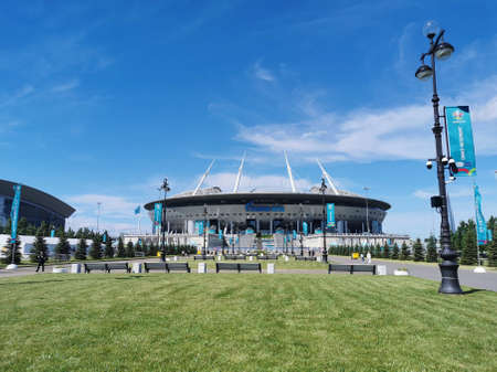 Lawn and benches in front of the Gazprom Arena stadium in St. Petersburg on the morning of the match day of the EURO 2020 European Football Championship against a blue sky with clouds.のeditorial素材