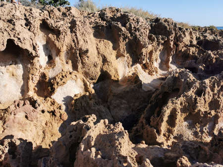 Protaras. Famagusta area. Cyprus. Long frozen lava, porous shore of the Mediterranean Sea.