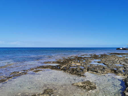 Protaras. Famagusta area. Cyprus. The coast of the Mediterranean Sea, long frozen lava, in the recesses of which there is sea water against a blue sky .の写真素材