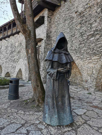 Tallinn.EstoniaA metal figure - a monk without a face against the background of one of the towers of the medieval defensive wall of the city. Wanalynn area. Old Tallinn.の写真素材
