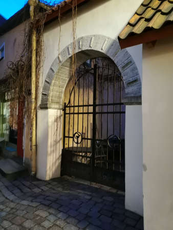 Closed gates in an arch against the blue sky on one of the streets of Old Tallinn. spring evening. Wanalynn area.の写真素材