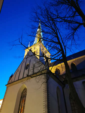 The large white Olaf Baptist Church on one of the streets of Old Tallinn against a dark blue sky. spring evening. Kesklinn.の写真素材