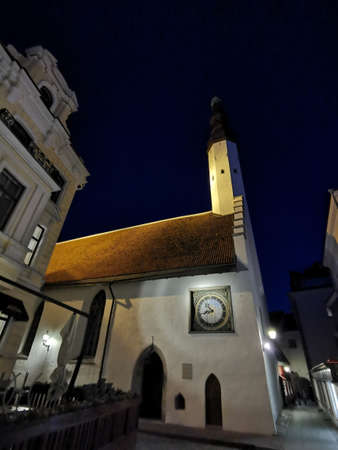 The Evangelical Lutheran Church of the Holy Spirit is an old white building with a clock against the blue sky on one of the streets of Old Tallinn. spring evening. Wanalynn area.の写真素材