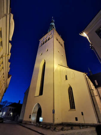 The large white Olaf Baptist Church on one of the streets of Old Tallinn against a dark blue sky. spring evening. Kesklinn.の写真素材