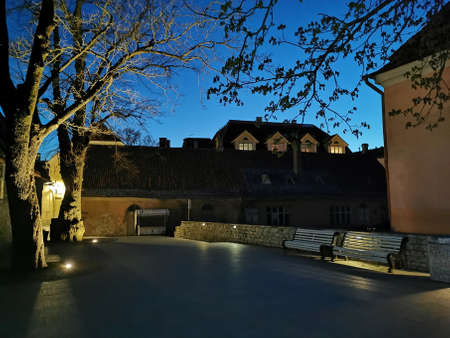 Empty white wooden benches next to the observation deck in Old Tallinn. spring evening. Kesklinn.