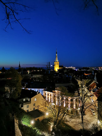 Panoramic view from the observation deck in the city center on the streets and buildings of Old and New Tallinn, on the tiled roofs, church spiers and new high-rise buildings. Evening in Estonia.の写真素材
