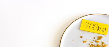 empty plate with crumbs and calories label. Concept counting kcal, food control, Intuitive eating, breakfast, banner.の写真素材