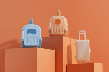Concept travel or moving with animal, flight, safety. Plastic cage, pet carrier and suitcase on orange backgroundの写真素材