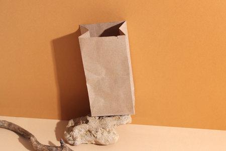 Brown craft paper bag pack on orange background. Concept zero waste, eco shop package, ecological packing. High quality photoの写真素材