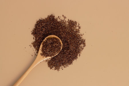 Brown texture scrub with cocoa coconut coffee in wooden spoon on brown background. spa and home care concept, beauty procedures.の写真素材