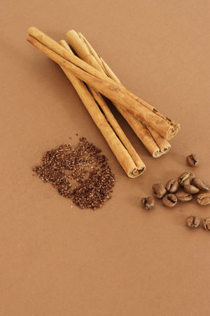 Home made texture scrub with cinnamon coffee on brown background. spa and home care concept, beauty procedures, vertical photo.の写真素材