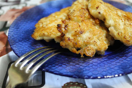 delicious juicy chicken cutlets with cheese on a blue plateの写真素材