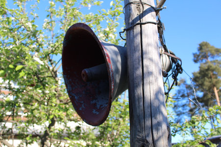 an old loudspeaker is hanging on a poleの写真素材