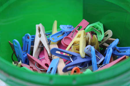 a lot of multi-colored clothes pins in a containerの写真素材