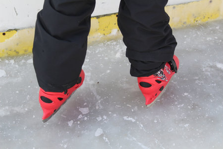 Legs in red skates on the iceの写真素材