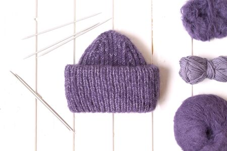 Knitted hat and needles on the white background. Woolen yarn balls. Top view. Flat layout.の写真素材