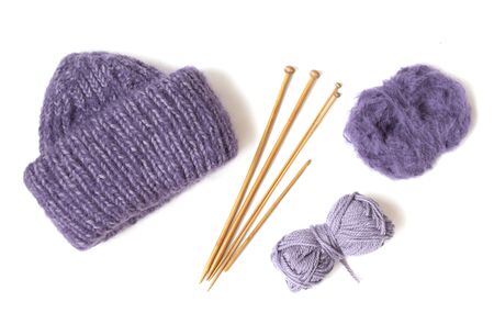 Knitted woolen hat, wooden needles and yarn balls on the white background. Top view. Flat layout.の写真素材