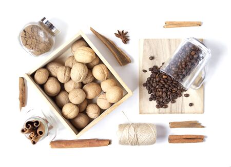 Beautiful layout with scattered coffee beans, walnuts in the wooden box, spices on the white background. Top view. Flat layの写真素材