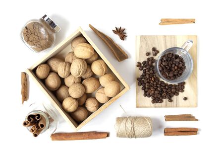 Beautiful layout with scattered coffee beans, walnuts in the wooden box, spices on the white background. Top view. Flat layの写真素材