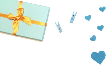 Blue box with orange ribbons, felt heart, colorful clothespins. Copy space. Place for text and design. Copy space. Place for text and design. White background.の写真素材