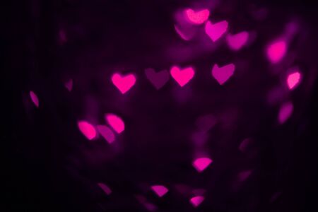 Lights out of focus. Pink hearts. Dark background. Copy space. Place for text and design. の写真素材