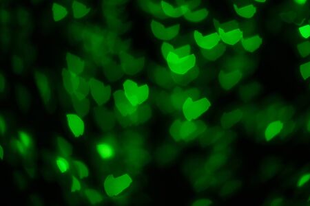 Green hearts out of focus. Colorful lights. Dark background. Copy space. Place for text and design. の写真素材