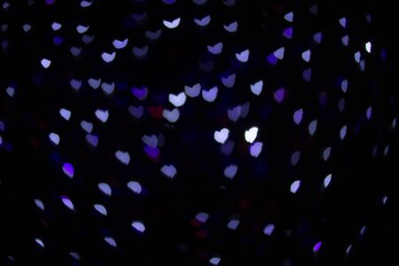 Colorful hearts out of focus. Colorful lights. Dark background. Copy space. Place for text and design.の写真素材