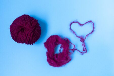 Blue background. Knitting courses. Online education. Flat lay. Top view. Place for text and design. Copy space. Knitting with love. Quarantine life. The heart of the threadの写真素材