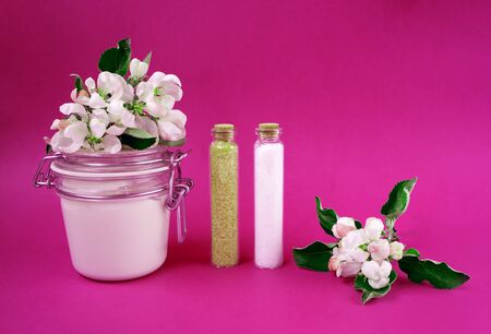 Hand made body cream or lotion, salt and sugar on the pink background. Apple blossoms. Natural cosmetics. Small business. Copy space. Glass jarの写真素材